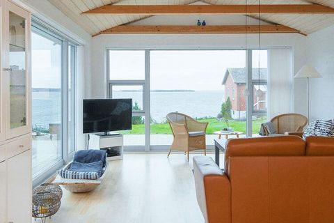 Holiday cottage at Egsmark Strand with whirlpool and panoramic views of Ebeltoft Vig. The house was renovated in 2018 and has a Scandinavian decor. Along with the large window sections in the living room it makes the house very bright and inviting. T...