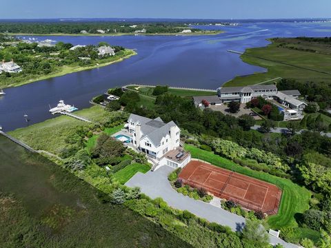 Step into a realm of pure Resort Style living and waterfront splendor within this newly designed Hamptons Bayfront masterpiece. Behind the estate gate, graciously situated on a serene and meticulously maintained 1.4 acres, ensconced by vibrant garden...