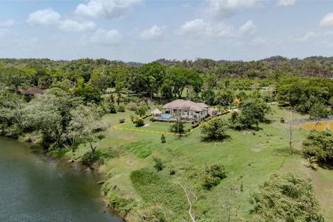 Geniet van een luxueus leven aan de rivier in dit prachtig ingerichte huis met 5 slaapkamers en 5 badkamers, compleet met overloopzwembaden en een zwembadbar in het zwembad op een groot perceel van een halve hectare in de luxe Olde Mill Residences; e...