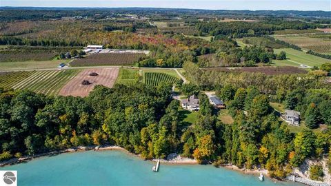 Home & Vineyard with private waterfront on Grand Traverse Bay! Exemplifying the relaxed luxury of Leelanau wine country, this picturesque estate combines serene natural elements & unbelievable elevated water views. Situated on 5 acres w/ an impressiv...