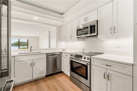 RARELY available end unit on first floor in Spinnaker Point! Beautifully renovated with spectacular RIVER VIEWS from main living areas and primary bedroom. Chic finishes include all white kitchen with shaker cabinets and quartz countertops, S/S Bosch...